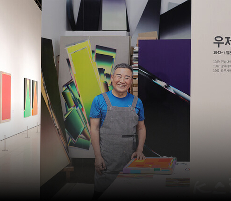 전시관에서 웃고 있는 남자 작가